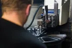 Technician operating an alloy wheel diamond-cutting lathe