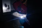 Technician welding a crack in an alloy wheel