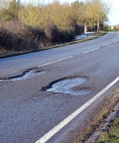 Pothole-ridden road that can damage alloy wheels and suspension