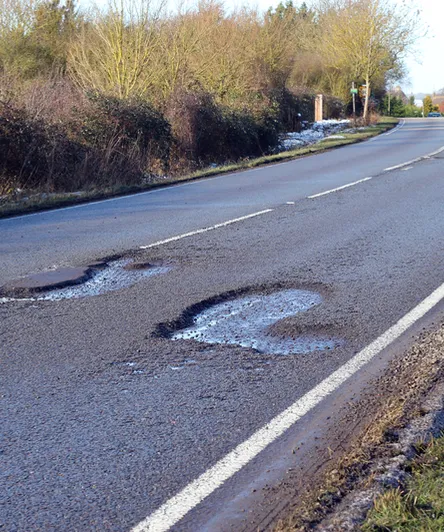 Pothole-ridden road that can damage alloy wheels and suspension