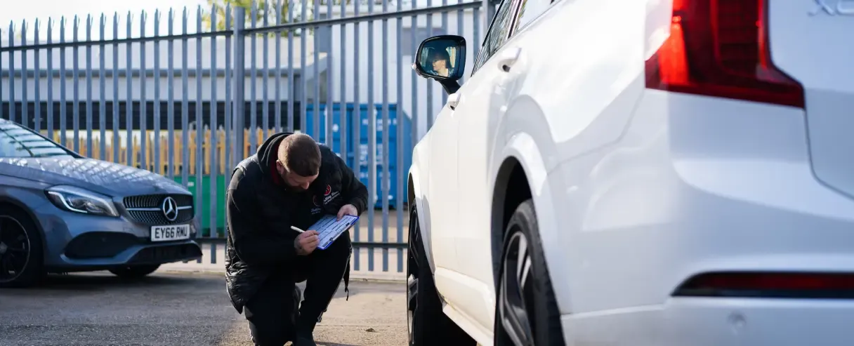 Rolling Rims employee checking the alloy wheels of the lease car and filling out the report sheet