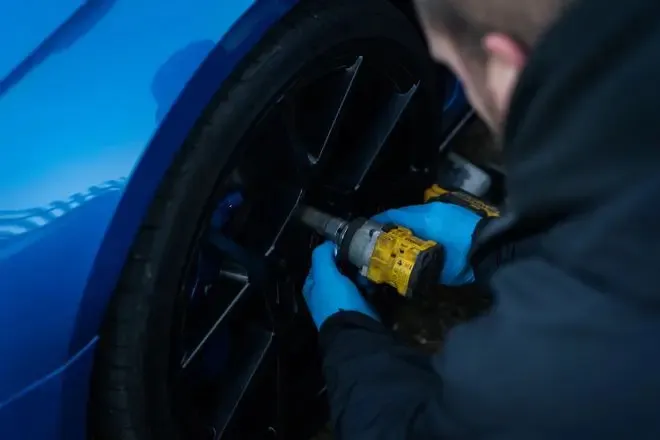 Rolling Rims employee removing a wheel from an Audi ready to take into the workshop