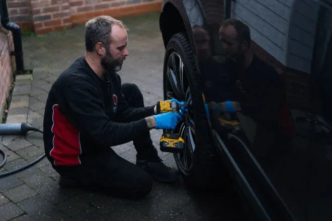 Rolling Rims employee removing an alloy wheel from a customers drive via the collection and delivery service