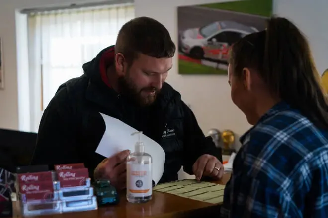 Rolling Rims employee explaining to the customer what needs attention before they return their lease car