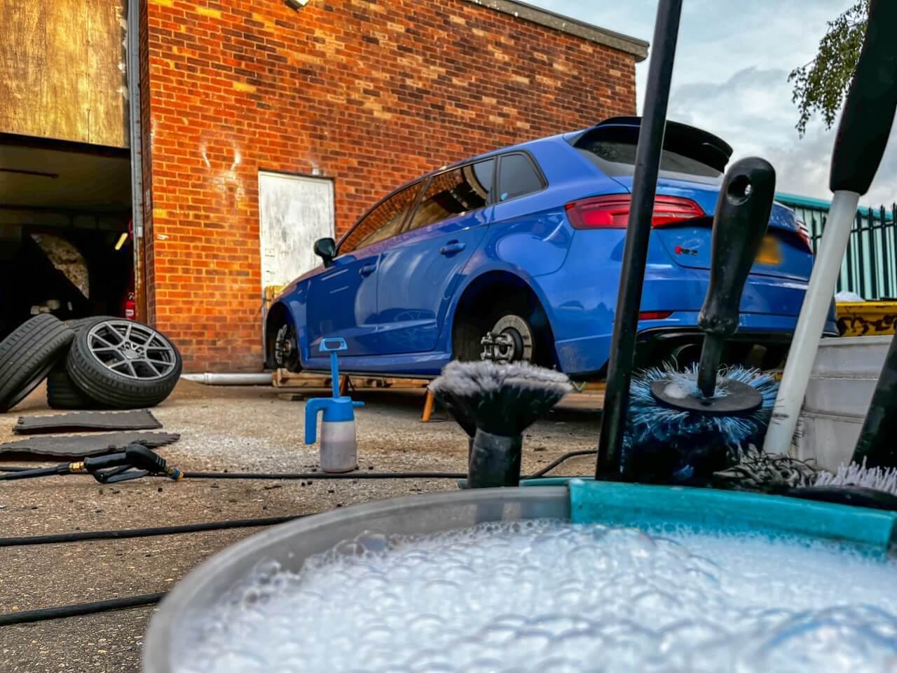 bucket full of cleaning solution ready to clean dirty alloy wheels