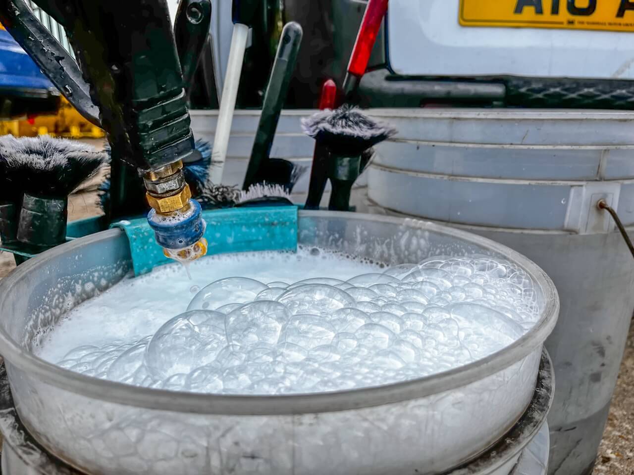 Mixing the cleaning solution with water in the bucket using the jet washer