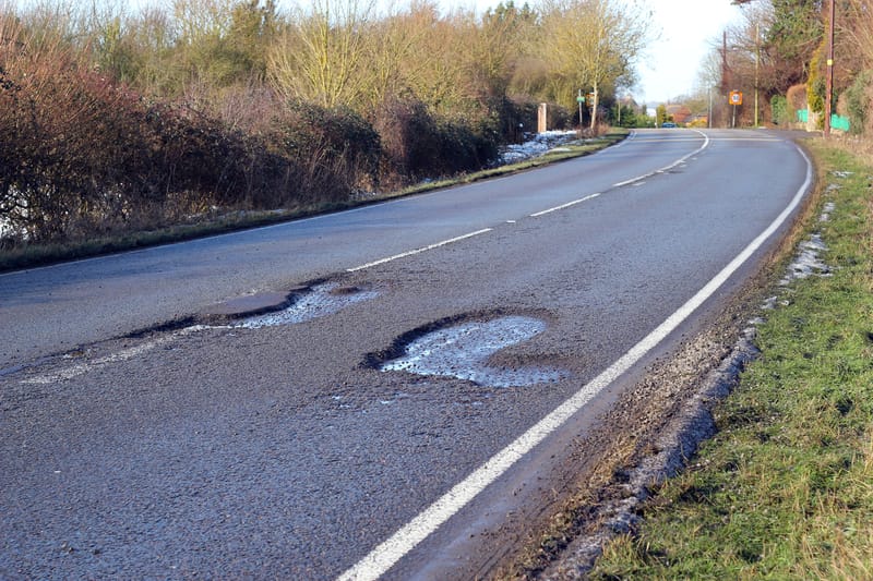 Pothole-ridden road in need of repair