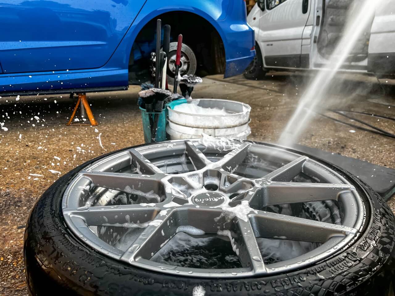 alloy wheel being rinsed of cleaning solution