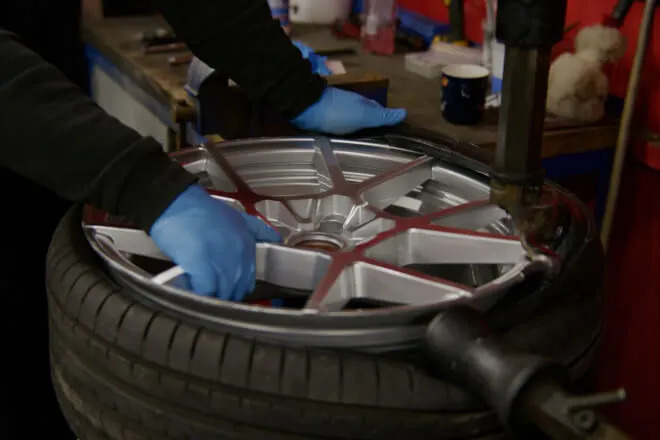 Rolling Rims employee fitting a tyre to the freshly refurbished alloy wheel