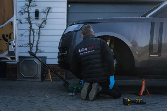 Rolling Rims employee removing a wheel from a Range Rover ready to take back to the workshop for refurbishment