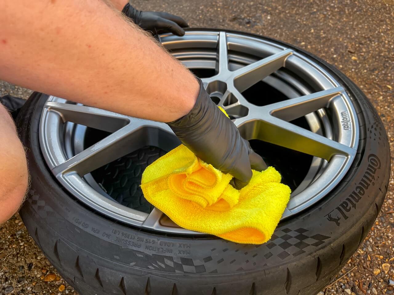 Buffing the alloy wheel to remove any excess coating with a yellow microfiber